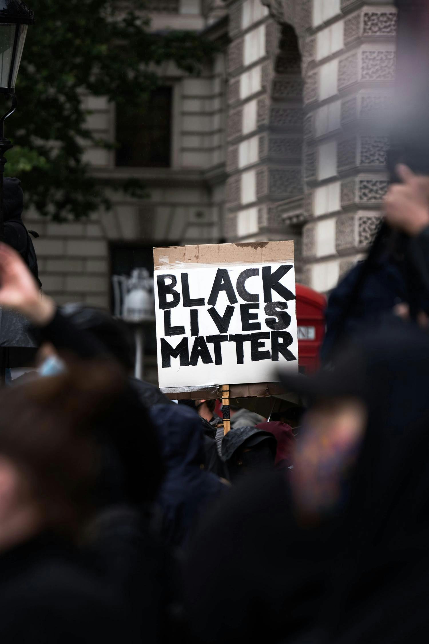 En person holder opp et skilt der det står "Black Lives Matter" under en protest.